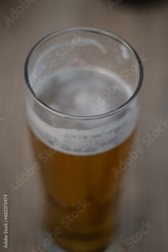 glass of beer on wooden table with swirly bokeh shot from high angle 