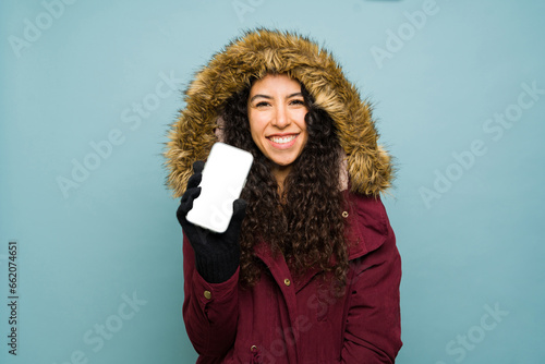 Beautiful woman texting on the phone during winter weather