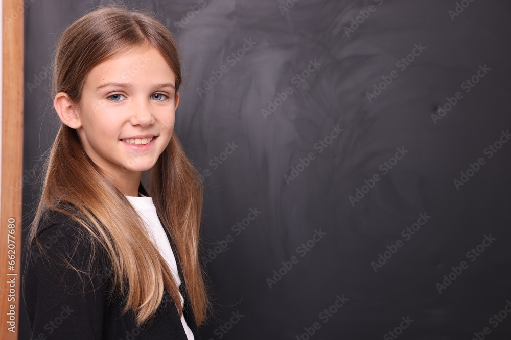 Smiling schoolgirl near blackboard. Space for text Smiling schoolgirl near blackboard. Space for text