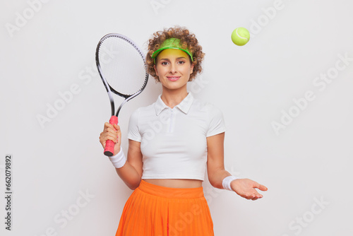 Young woman in t-shirt and skirt plays with the ball in one hand, holds the racket with the other hand, sport life concept, copy space © South House Studio
