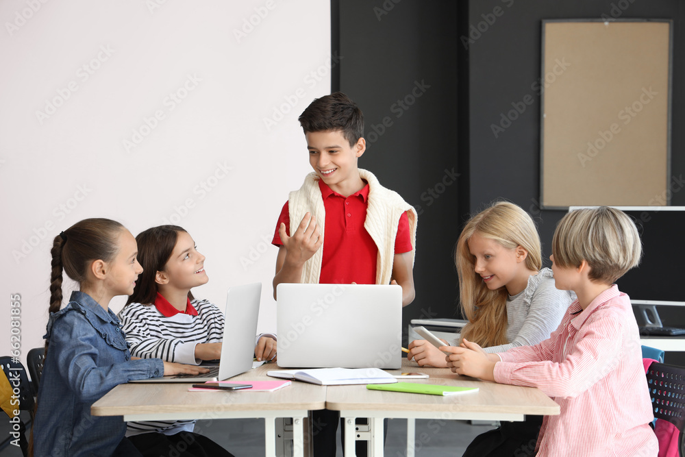 Fototapeta premium Little children studying with devices at school computer lab