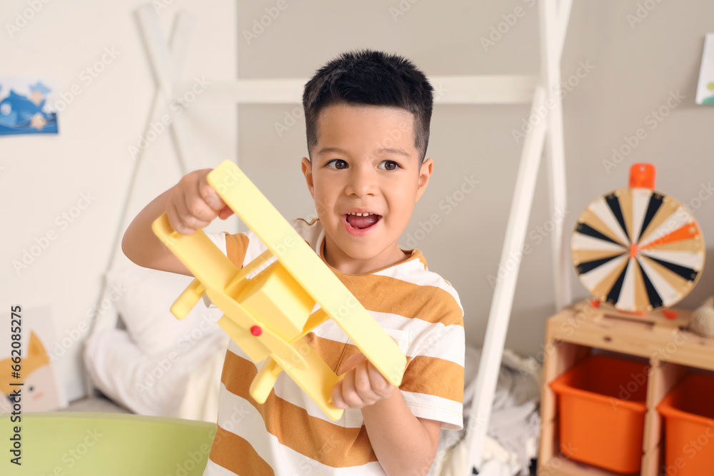 Little Asian boy playing with toy plane at home Little Asian boy playing with toy plane at home
