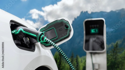 Electric car plugged in with charging station to recharge battery by EV charger cable with nature vacation background. Future innovative ev car and energy sustainability. Peruse
