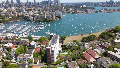 Aerial drone pullback reverse view above the harbourside suburb of Darling Point in east Sydney, NSW Australia, looking toward Sydney Harbour and Sydney City on a sunny day photo