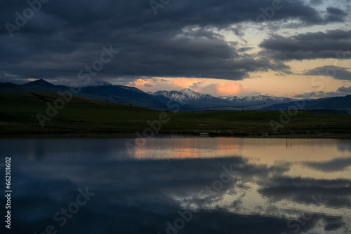 2022-06-07 A SMALL FISHING LAKE IN PRAY MONTANA WITH MOUNTAINS INTHE DISTANCE A NICE REFLECTION AND A MOODY CLOUDY SKY IN MONTANA