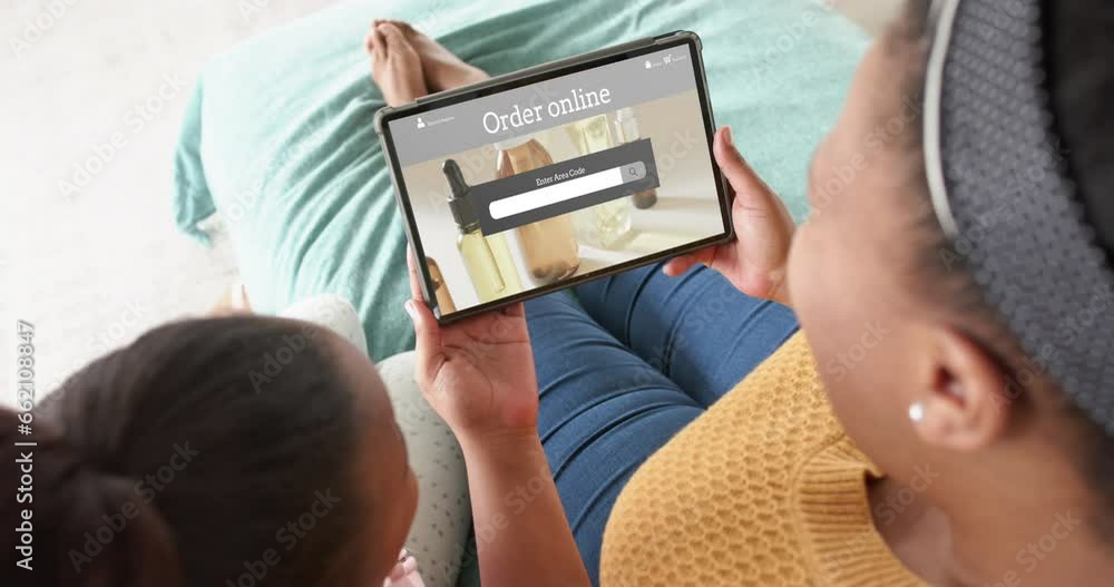 African american mother and daughter using tablet, online shopping for beauty products, slow motion African american mother and daughter using tablet, online shopping for beauty products, slow motion