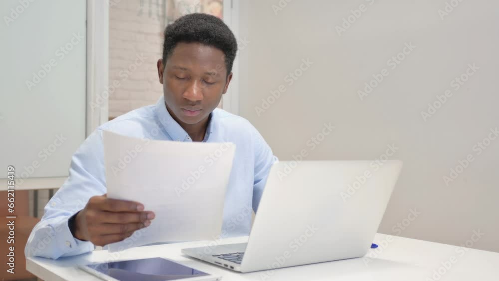 African Businessman Reading Documents at Work African Businessman Reading Documents at Work