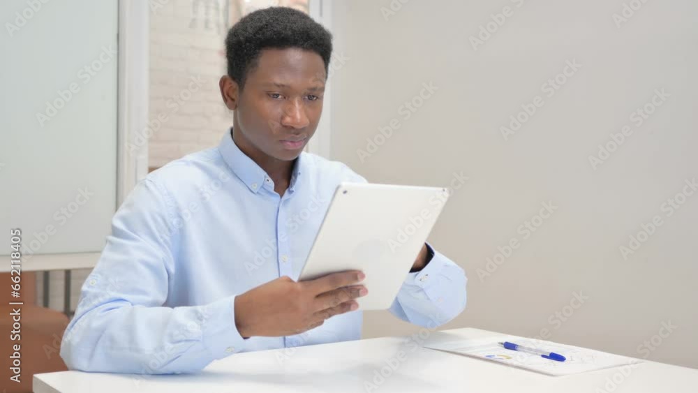 African Businessman Using Digital Tablet in Office African Businessman Using Digital Tablet in Office
