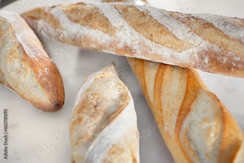 A closeup view of a patio table full of several French baguettes.