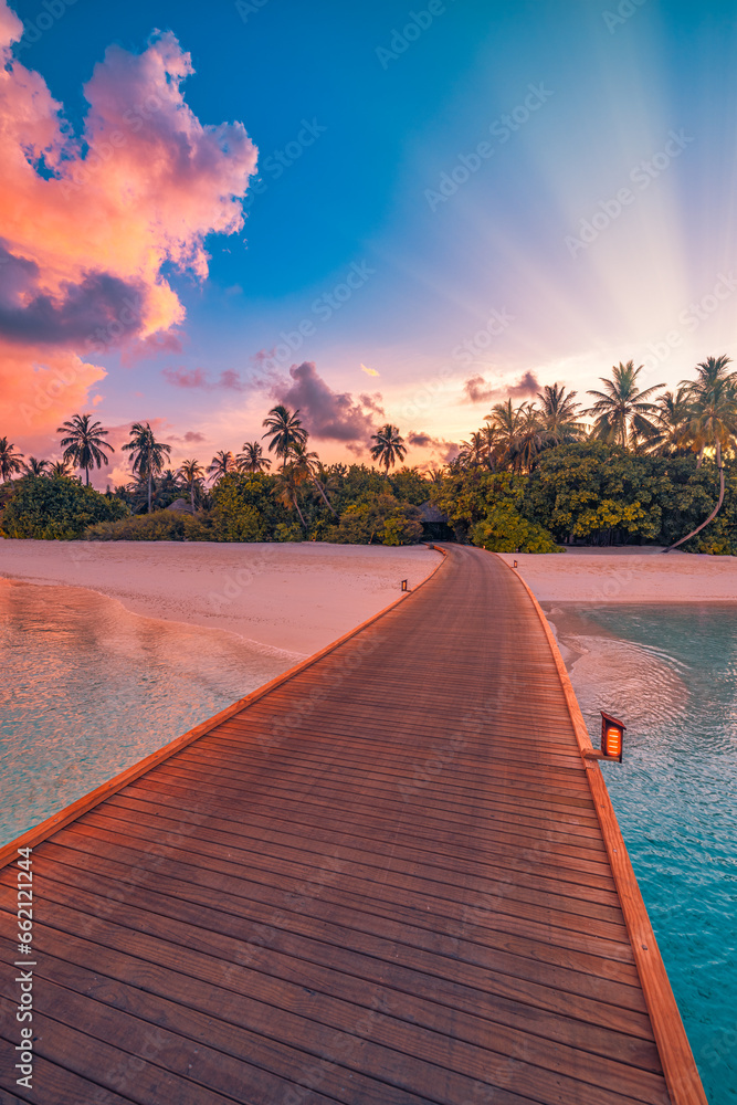 Amazing sunset panorama Maldives. Luxury resort pier path seascape romantic led lights colorful sky clouds. Paradise island coconut tree silhouette. Best travel beach background. Panoramic vacation