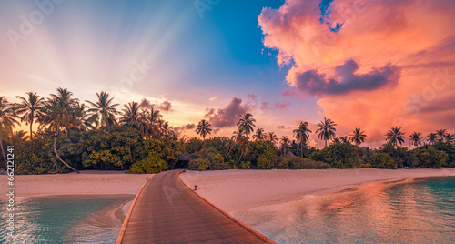 Fototapeta Naklejka Na Ścianę i Meble -  Amazing sunset panorama Maldives. Luxury resort pier path seascape romantic led lights colorful sky clouds. Paradise island coconut tree silhouette. Best travel beach background. Panoramic vacation