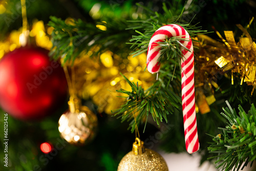 Close up of christmas tree with candy cane, baubles, decorations and copy space