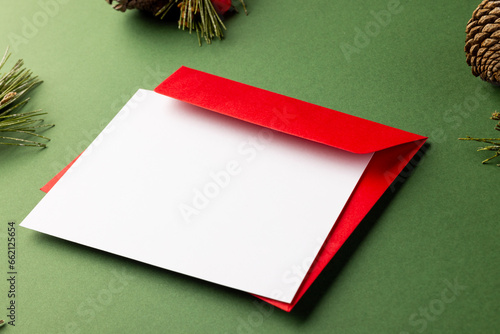 Christmas decorations with white card and copy space on green background
