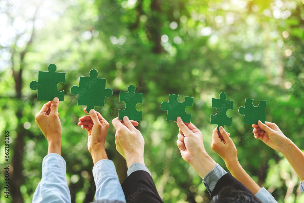 World environment day  and ESG Concept of teamwork and partnership Hands join Jigsaw puzzle pieces with global community sustainable Save Earth. the Environment World Earth Day concept - obrazy, fototapety, plakaty 