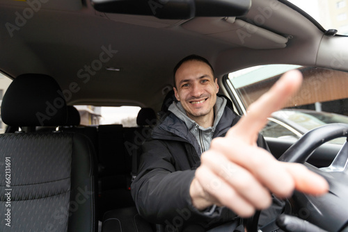 Joyful indian man driving car, shot from dashboard, going on trip during summer vacation, copy space. Happy middle-eastern guy in casual outfit and glasses driving his brand new nice car © Angelov