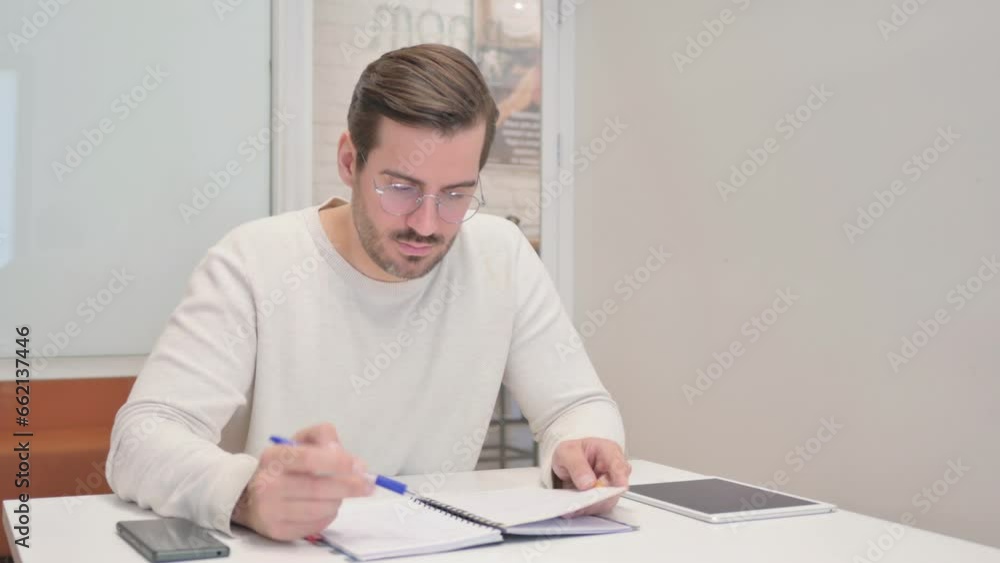 Reading Young Man Checking Documents in Office Reading Young Man Checking Documents in Office