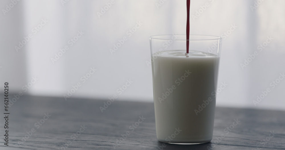 pour natural berry juice in organic yogurt in tumbler glass on black wood table with copy space