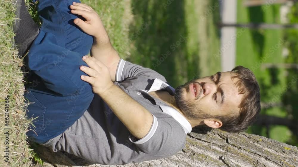 Vertical Video of Depressed and thoughtful dwarf young man sits on the floor. Vertical Video of Depressed and thoughtful dwarf young man sits on the floor.