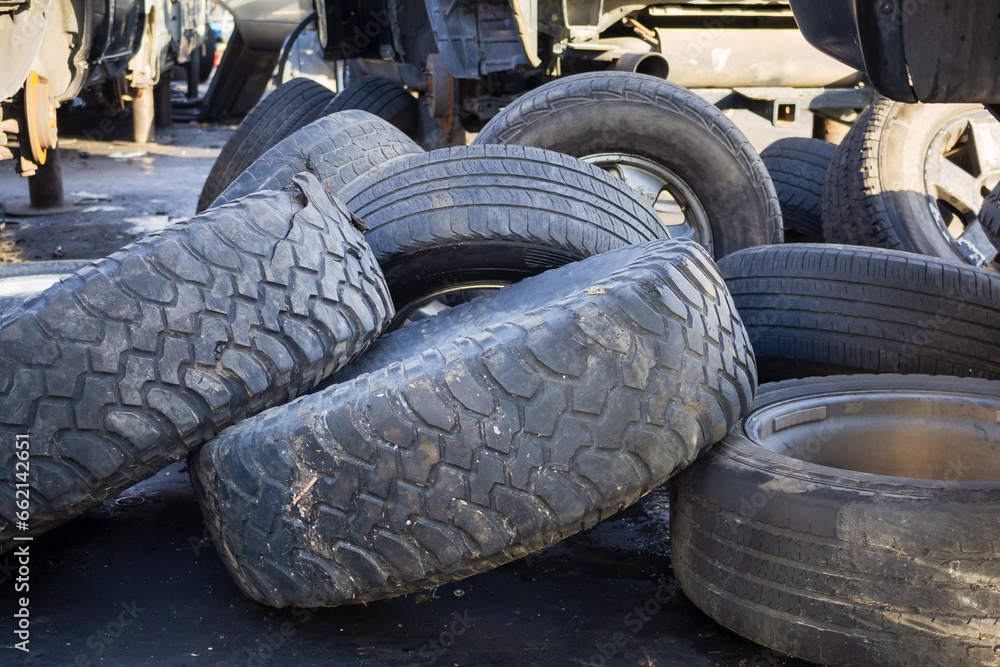 A view of several large used and damaged tires. A view of several large used and damaged tires.