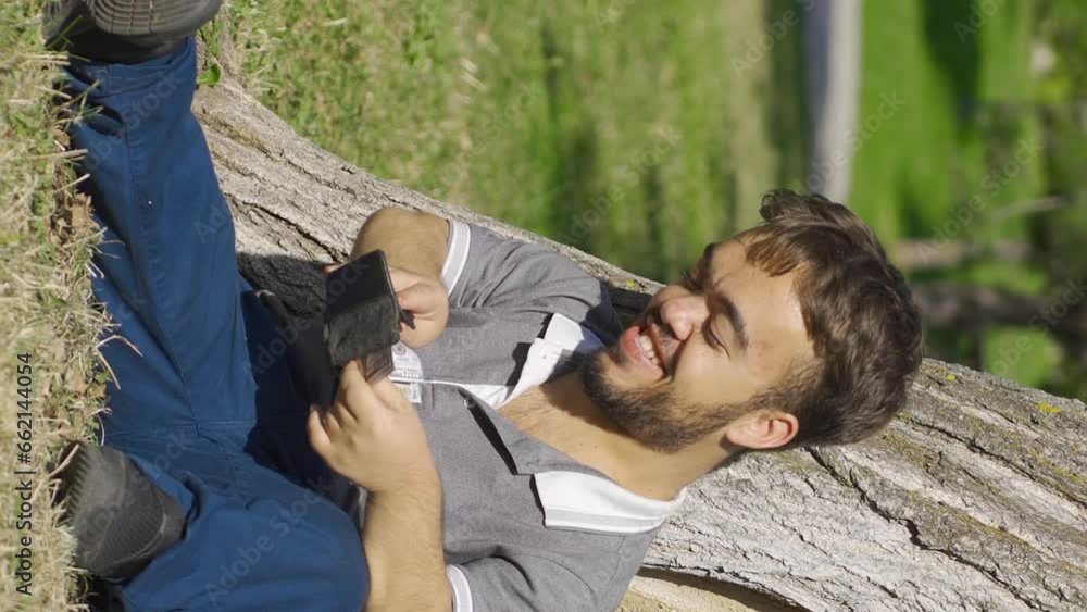 Vertical Video of Dwarf young man with money is sitting outdoors and is happy. Vertical Video of Dwarf young man with money is sitting outdoors and is happy.