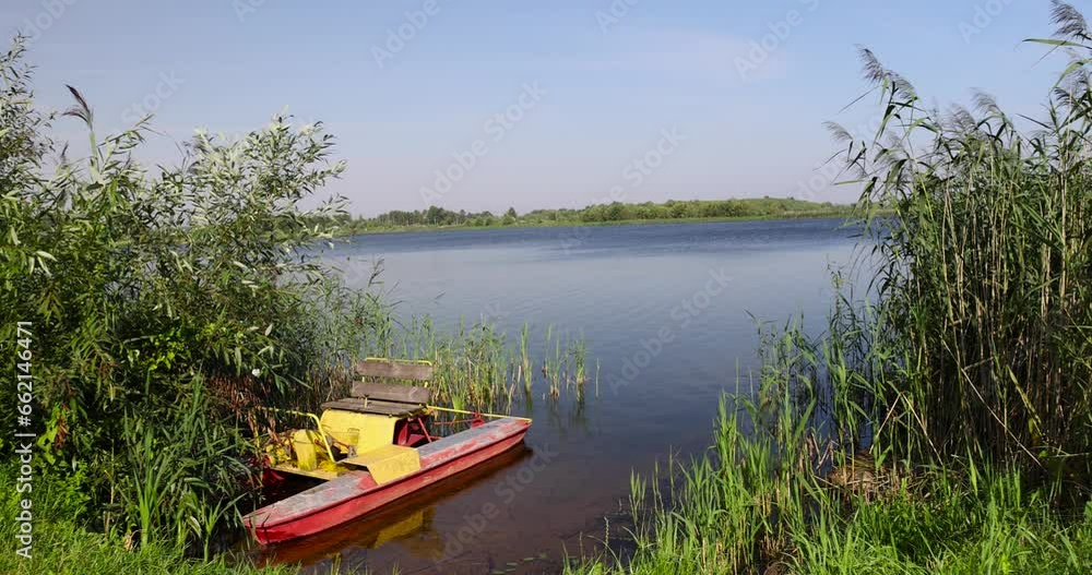 old catamaran on the lake shore, one old catamaran for walking on the lake in the summer season old catamaran on the lake shore, one old catamaran for walking on the lake in the summer season