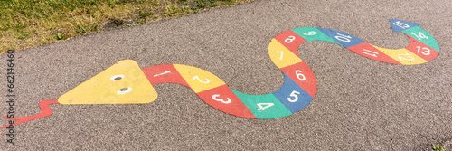 Colorful Snakes Board Game with Numbers on playground floor. Outdoor activity for Kids, learn and play. Panorama