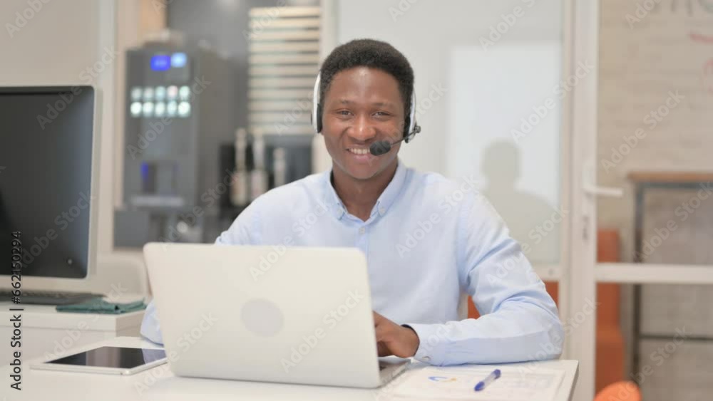 Smiling African Man with Headset Looking at Camera in Call Center Smiling African Man with Headset Looking at Camera in Call Center