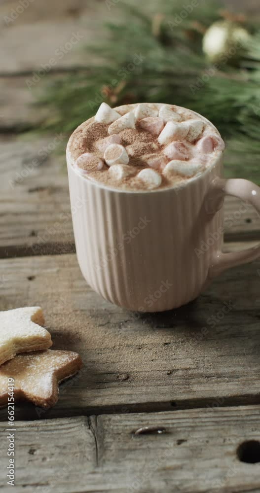 Vertical video of mug of christmas chocolate with marshmallows and copy space on wooden background Vertical video of mug of christmas chocolate with marshmallows and copy space on wooden background