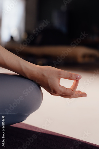 Close-up front view of woman doing yoga sitting on yoga mat. Woman doing yoga on a light background photo