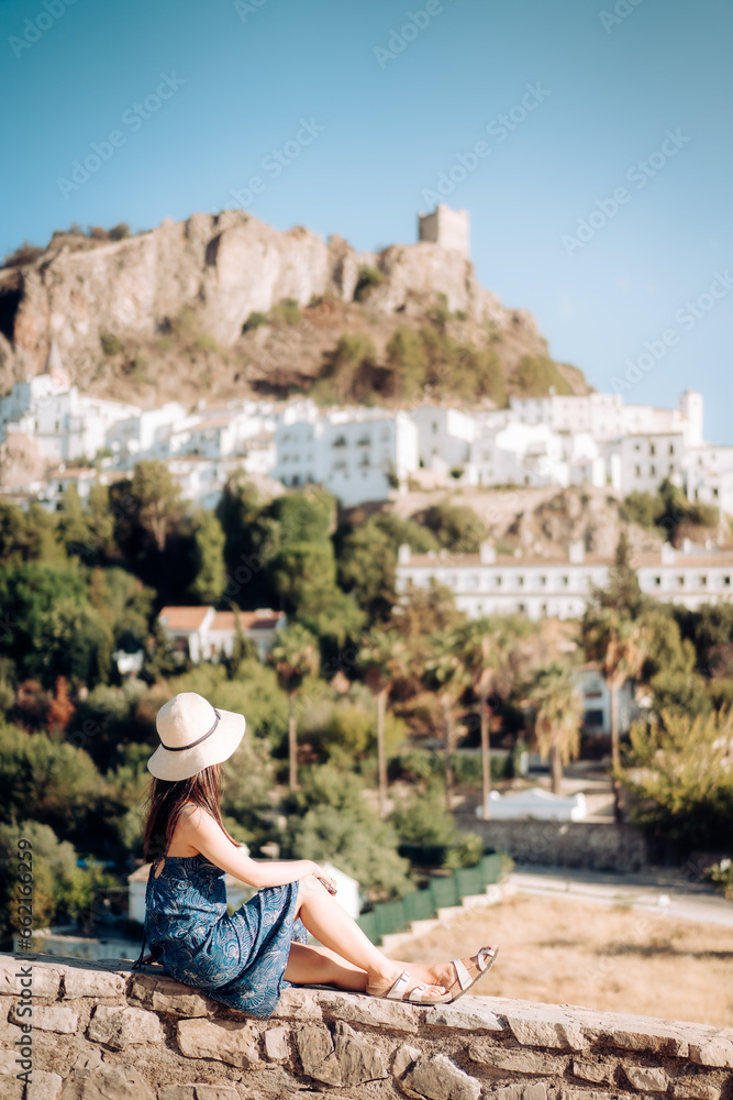 Woman in travel, Asian woman in blue dress looking at the old city, Zahara de la Sierra in Cadiz, Spain