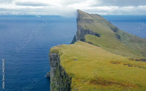 Foggy mountain peaks and clouds covering sea and mountains. Panoramical view from famous place - Sornfelli on Streymoy island, Faroe islands, Denmark. Landscape photography photo