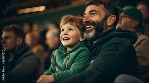 Irish father and son in stands, filled with enthusiastic supporters of rugby or football team wearing green clothes to support national sports team photo