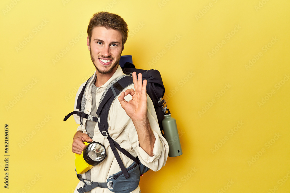 Traveler with mountain backpack and torch cheerful and confident showing ok gesture. Traveler with mountain backpack and torch cheerful and confident showing ok gesture.