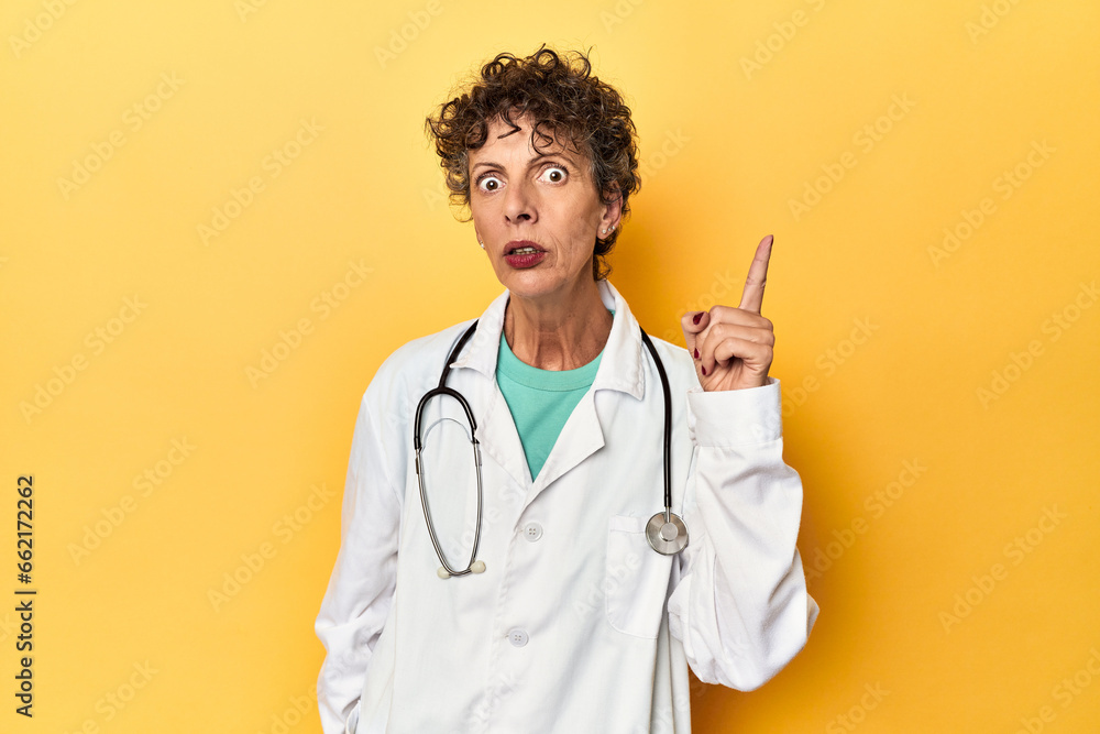 Caucasian mid-age female doctor on yellow studio having an idea, inspiration concept. Caucasian mid-age female doctor on yellow studio having an idea, inspiration concept.
