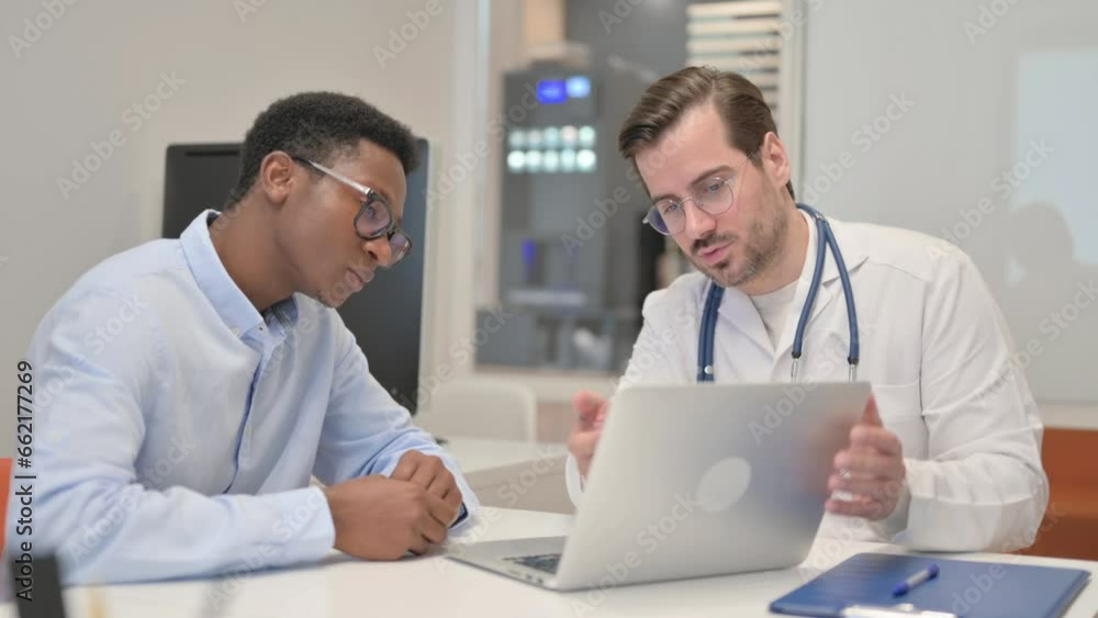 Doctor Talking and Showing Patient Report on Laptop Doctor Talking and Showing Patient Report on Laptop