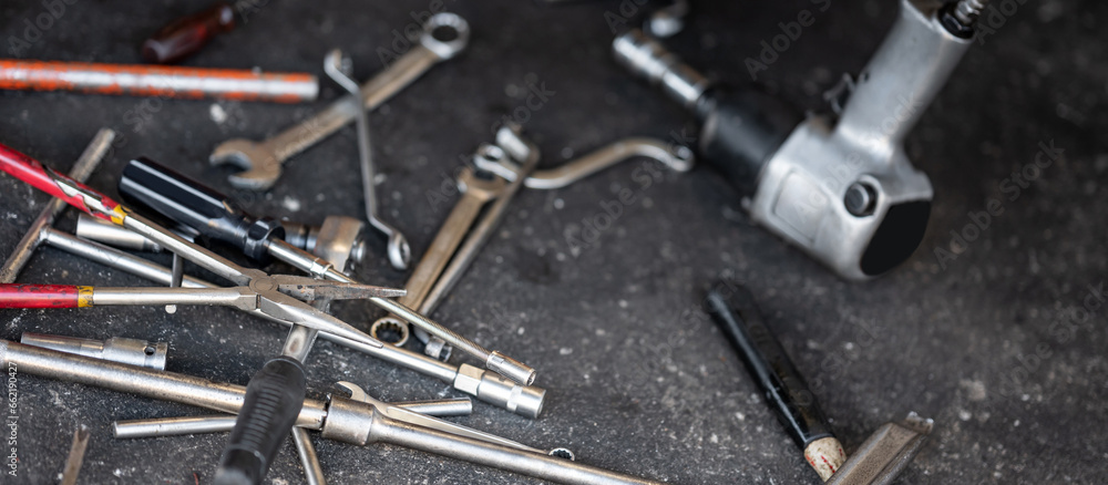 Many auto mechanic work tools on concrete floor in garage Many auto mechanic work tools on concrete floor in garage