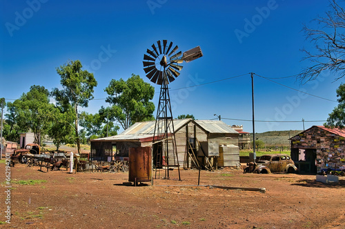 House made of corrugated iron, rusty old cars and a windmill in Gwalia ghost town in the Great Victoria Desert, shire of Leonora, Western Australia
