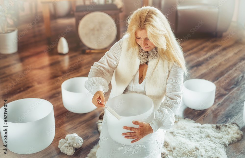 Woman playing on a crystal bowl. Ceremony space. Woman playing on a crystal bowl. Ceremony space.