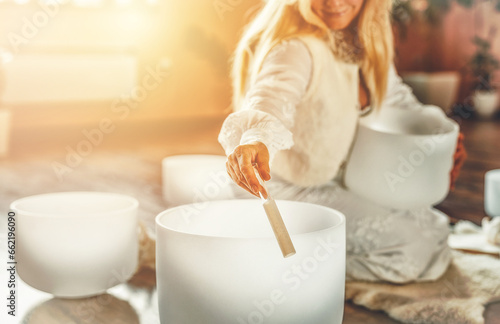 Woman playing on a crystal bowl. Ceremony space.