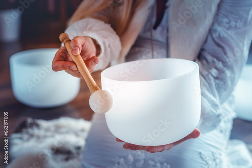Woman playing on a crystal bowl. Ceremony space.