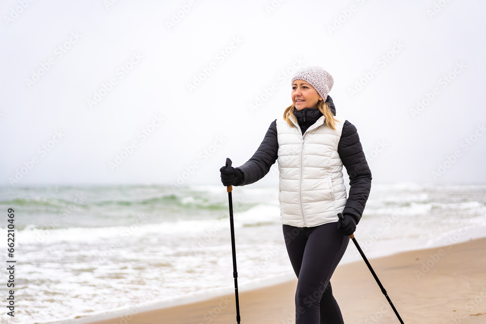 Nordic walking - beautiful woman exercising on beach
 - obrazy, fototapety, plakaty 