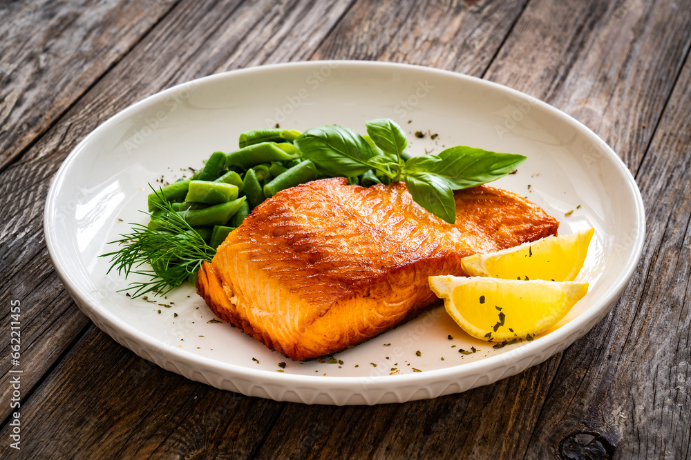 Seared salmon steak with green bean and lemons on wooden table
Seared salmon steak with green bean and lemons on wooden table