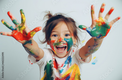 a little girl painting with her hands and arms