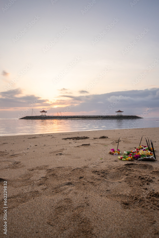 Sunrise at the sandy beach of Sanur. Temple in the water. Offerings by the sea on the beach. Hindu faith in Sanur on Bali. Dream island and dream destination Sunrise at the sandy beach of Sanur. Temple in the water. Offerings by the sea on the beach. Hindu faith in Sanur on Bali. Dream island and dream destination