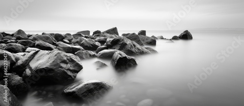 Long exposure photograph of a rocky seascape scene at Odessa Ukraine featuring black sea and white tones With copyspace for text