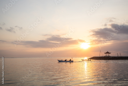 Sunrise at the sandy beach of Sanur. Temple in the water. Traditional fishing boat, Jukung on the beach. Hindu faith in Sanur on Bali. Dream island and dream destination © Jan