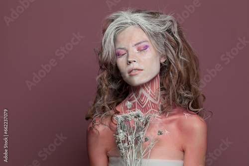 Photos Young nice woman with makeup and pattern on her body, studio portrait