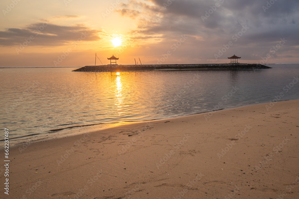 Landscape shot in Bali. Sunrise or sunset at Sanur beach. Beautiful sandy beach in the morning, with fine sand and a view of the calm sea. Temples are in the water. A dream in Indonesia