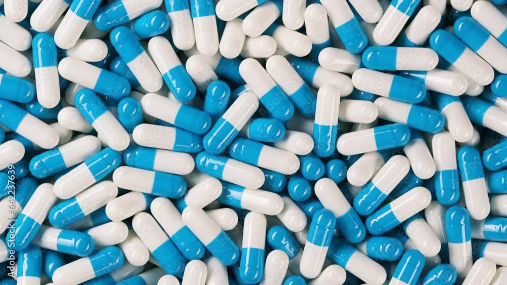 Blue white capsules top view, rotation. Pills and drugs. Pharmaceutical Industry. The medicine concept Blue white capsules top view, rotation. Pills and drugs. Pharmaceutical Industry. The medicine concept