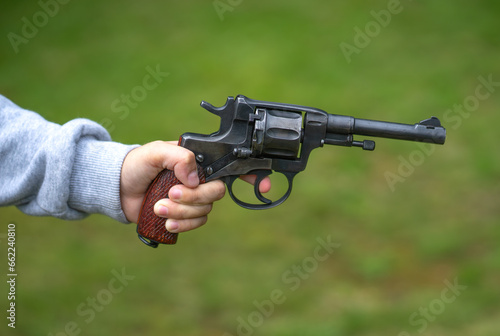 A child's hand with a revolver. Armed robbery on the street. A boy with a gun.